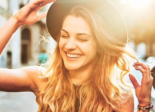 smiling woman with the sun behind her