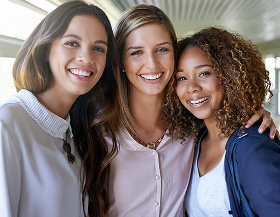 group of three smiling female friends