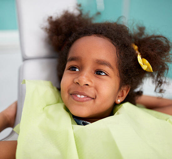 smiling young girl sitting in a dental chair